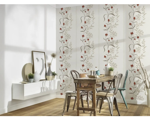 Eetkamer met bloemenbehang, houten tafel en stoelen.