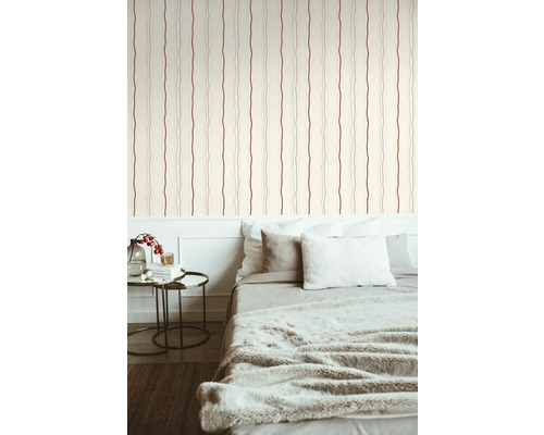 Slaapkamer met bed tegen een gestreept behang