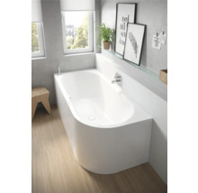 Badkamer met wit ligbad en houten vloer