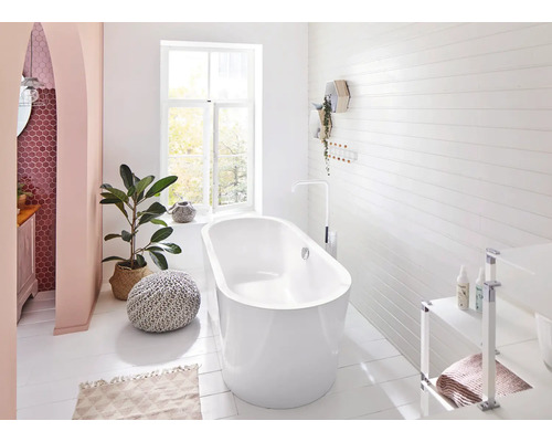 Badkamer met vrijstaand bad, raam en decoratieve elementen voor een lichte en vriendelijke sfeer