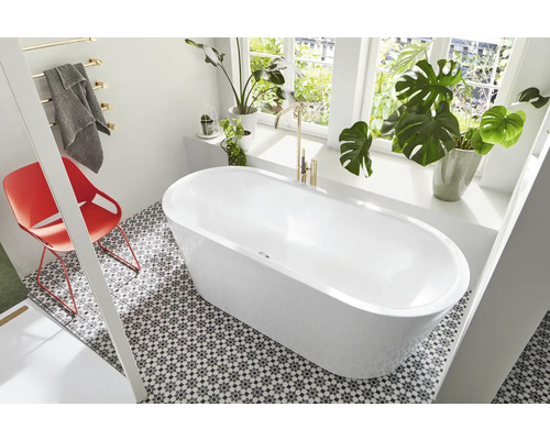 Moderne badkamer met vrijstaand bad, tegelvloer en kamerplanten bij het raam