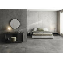 Slaapkamer met bed, spiegel, tafel en vloertegels in betonlook