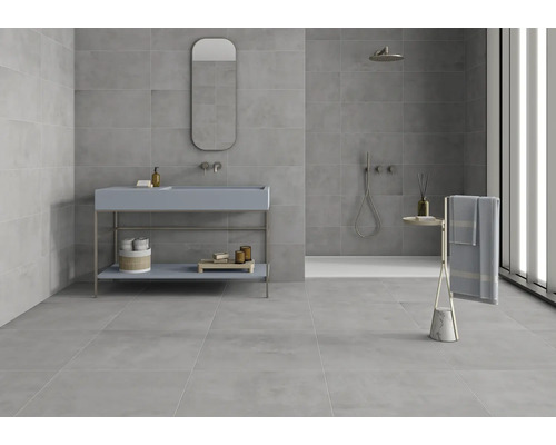 Lichte badkamer met grijze tegels, wastafel met spiegel en douche