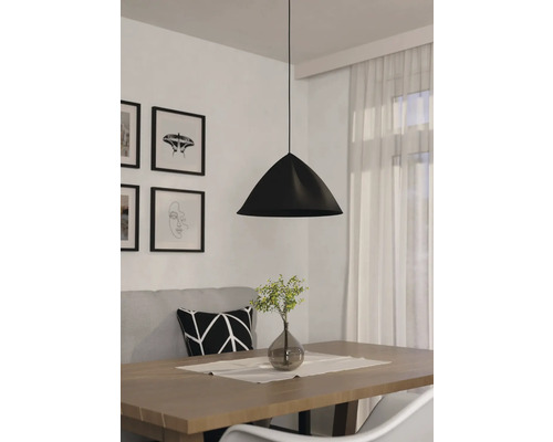 Zwarte hanglamp boven een eettafel met decoratie