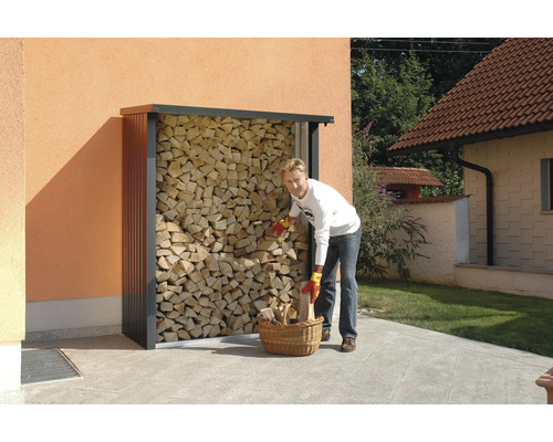 Persoon vult houten mand bij een houtopslag