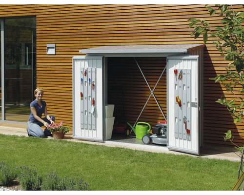 Tuinkast met open deuren, uitgerust met tuingereedschap, grasmaaier en gieter in de tuin.