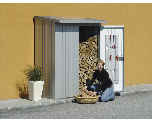 Vrouw vult hout in een mand voor een houtopslag met gereedschapshouder aan de deur.