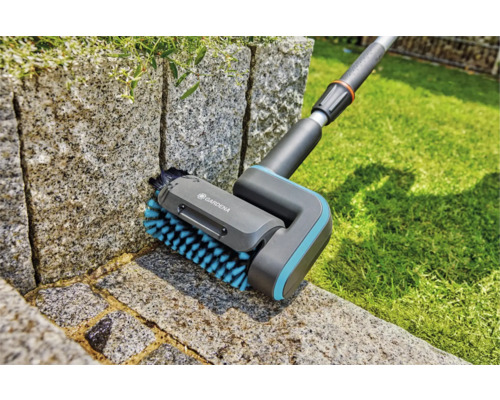 Gardena borstel voor het reinigen van voegen in gebruik op een stenen muur