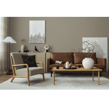 Woonkamer met leren bank, fauteuil, houten tafel en decoratieve elementen voor een stijlvolle inrichting