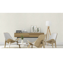 Lichte woonkamer met gestructureerd behang, houten fauteuil, staande lamp en dressoir