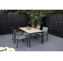 Tuinscene met eettafel en vier stoelen buiten.