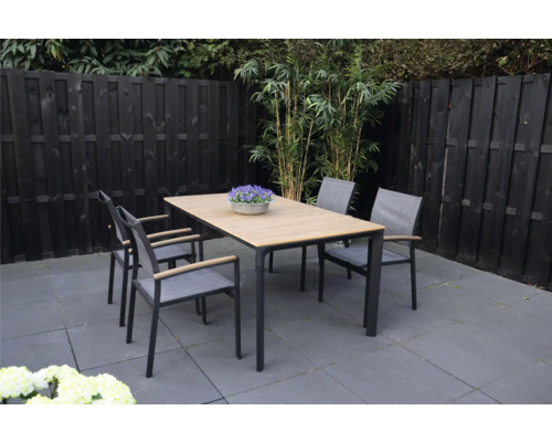 Tuinscene met eettafel en vier stoelen buiten.