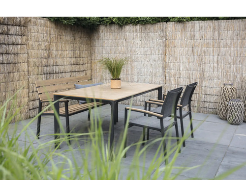 Tuinscene met eettafel, bank en stoelen voor een gevlochten schutting