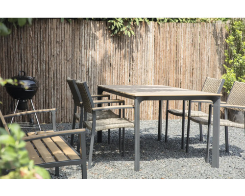 Tuinscene met tuintafel, stoelen, barbecue en houten schutting