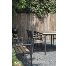 Tuinscene met barbecue, eettafel en stoelen voor een houten schutting