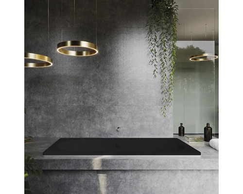 Badkamer met zwart bad, grijze muur en ronde plafondlampen