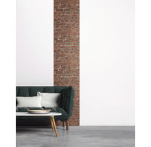 Woonkamer met bank, salontafel en bakstenen muur