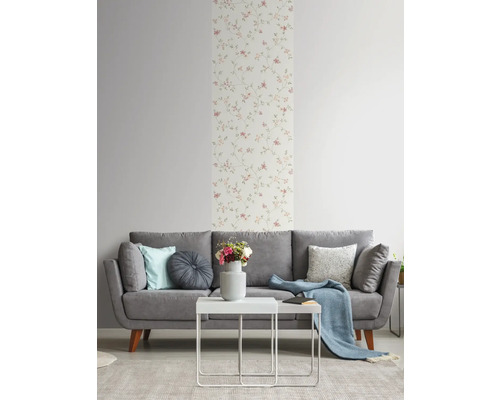 Woonkamer met grijze bank, witte tafel en bloemenbehang