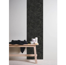 Decoratieve wanddecoratie met marmerlook naast een houten bank met badkamerbenodigdheden.