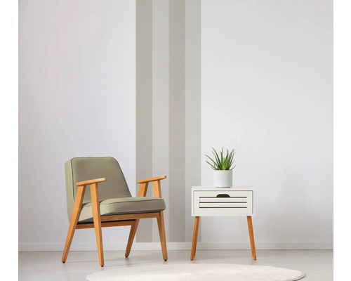 Fauteuil en nachtkastje met plant in lichte kamer