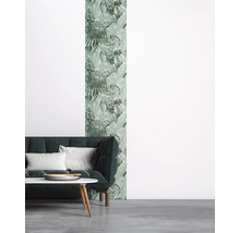Woonkamer met bank, tafel en wandbekleding met plantenmotief