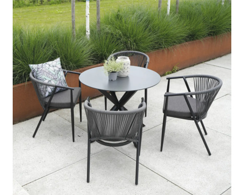 Tuinopstelling met ronde tafel en vier stoelen met armleuningen en kussens.