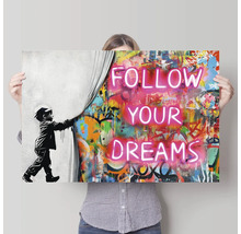 Muurdecoratie met de tekst Volg je dromen, een persoon houdt de foto omhoog