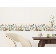 Wandborder met bloemenpatroon in een heldere ruimte met stoel en tafel