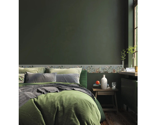 Slaapkamer met bed, nachtkastje en bloemenrand op de muur