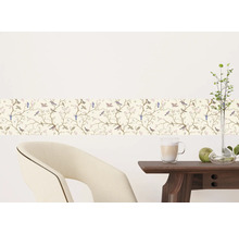 Wandbordüre met vogel- en bloemmotief in een kamer met stoel en tafel