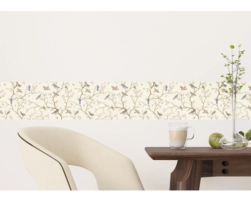 Wandbordüre met vogel- en bloemmotief in een kamer met stoel en tafel