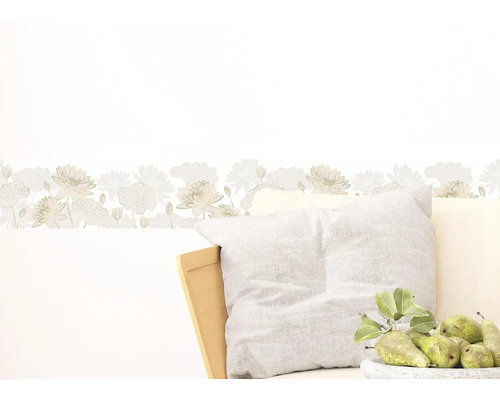 Wandbordüre met bloemmotief boven een kussen en een schaal met peren.
