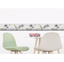 Borduur met jungle motief in kinderkamer boven een tafel met speelgoed en stoelen