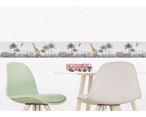 Borduur met jungle motief in kinderkamer boven een tafel met speelgoed en stoelen