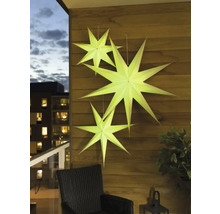 Decoratieve papieren sterren hangen aan een houten muur op een balkon.