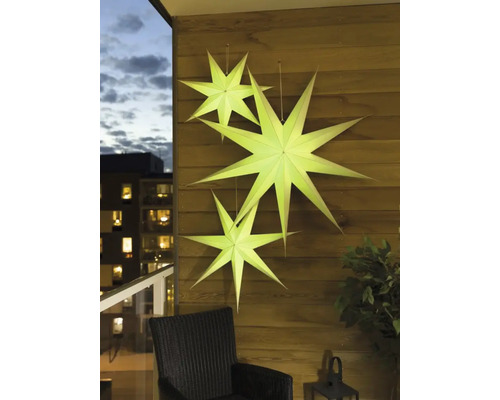 Decoratieve papieren sterren hangen aan een houten muur op een balkon.