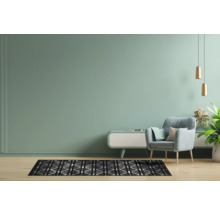 Lichte woonkamer met vloerkleed, fauteuil en decoratieve elementen