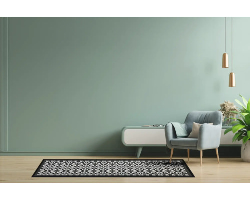 Woonkamer met fauteuil, vloerkleed met patroon en decoratie