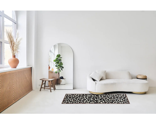 Lichte kamer met bank, spiegel en tapijt met dierenprint