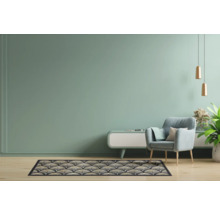 Woonkamer met fauteuil, tapijt met patroon en dressoir