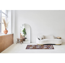 Woonkamer met bank, spiegel en vloerkleed met bloemmotief