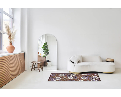 Woonkamer met bank, spiegel en vloerkleed met bloemmotief