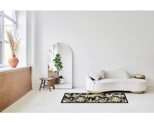 Woonkamer met bank en tapijt met plantenmotief