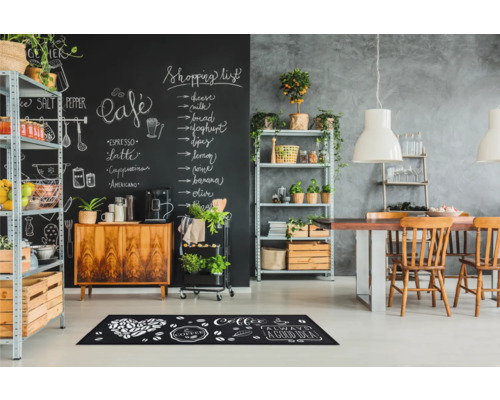 Scene van een eetkamer met krijtbordmuur, rekken en een vloermat met koffiemotieven.