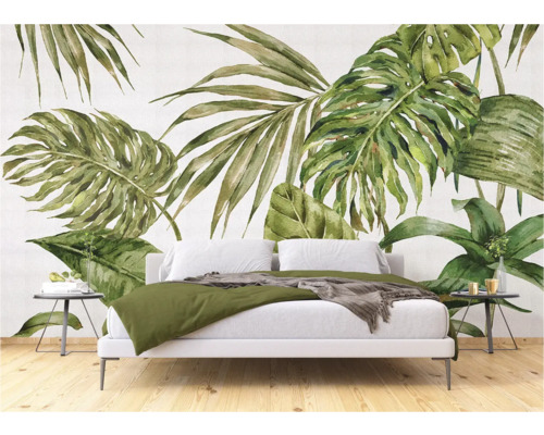 Slaapkamer met een witte beddengoedset voor een behang met tropische bladeren