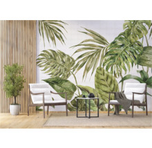 Decoratief interieur met tropische bladeren muurschildering, fauteuils en bijzettafel.