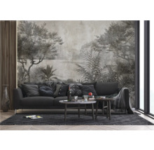 Woonkamer met grijze bank, salontafel en wandbekleding met landschapsthema.