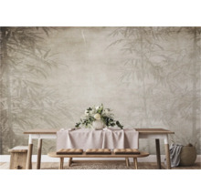 Wand met bamboemotief, tafel en zitbank met kussens in een heldere ruimte