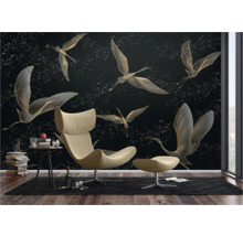 Woonkamer met behang met vogelmotieven, fauteuil en bijzettafel.