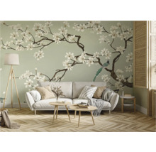 Woonkamer met bank, tafellamp en behang met bloemen- en vogelmotief